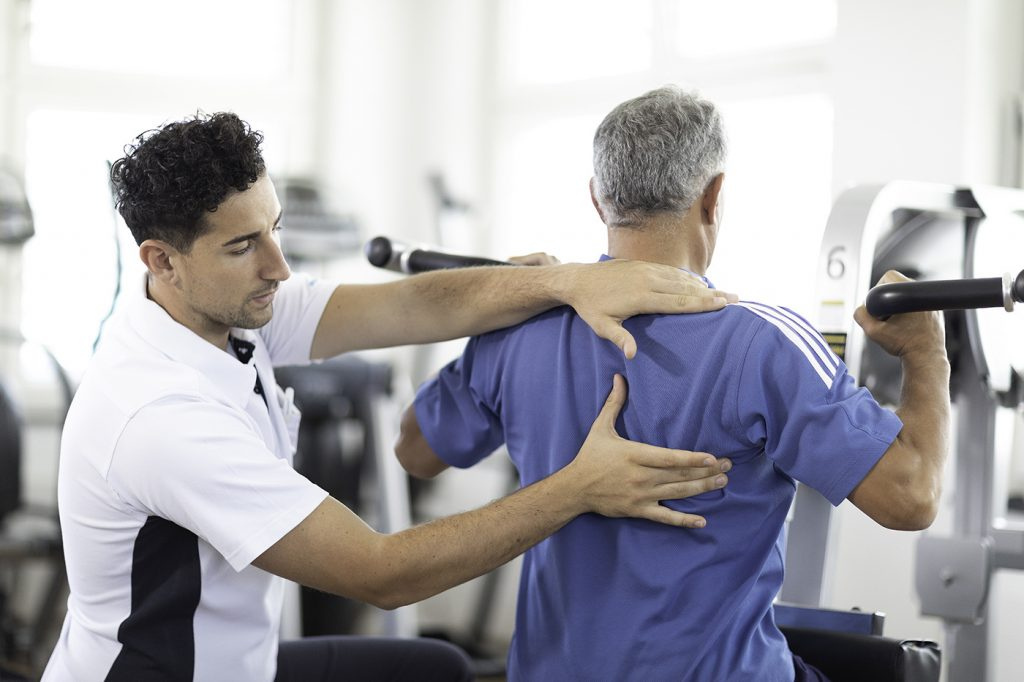 Patient und Physiotherapeut bei Übung mit Schulterprothese