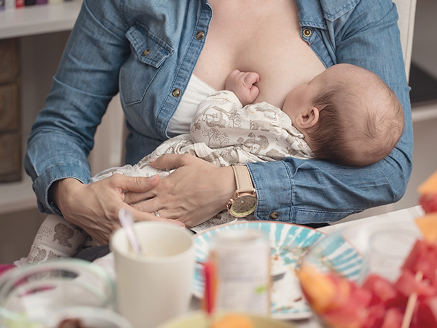 Frau beim Essen stillt Baby, Ernährung während der Stillzeit